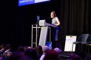2023 Scientific Chair, Dr Lisa Furlong, presenting at a lectern.
