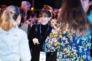 Group of attendees mingling, with one smiling