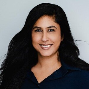 Headshot of Dr Salma Charania. She has long dark hair, is wearing a dark blouse and is smiling at the camera.