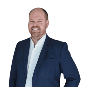 Headshot of Dr Shaun Ziegenfusz. He is wearing a blue blazer and is smiling at the camera.